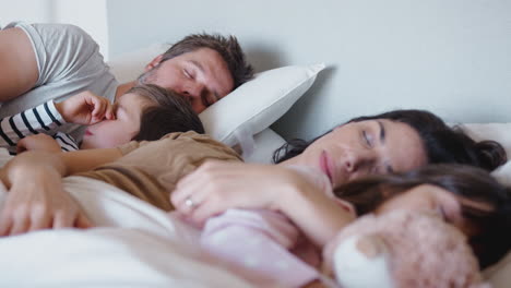 Friedliche-Eltern-Mit-Kindern,-Die-Zusammen-Im-Bett-Schlafen