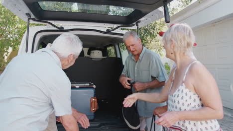 Eine-Gruppe-älterer-Freunde-Lädt-Gepäck-In-Den-Kofferraum-Eines-Autos,-Das-Kurz-Vor-Der-Abreise-In-Den-Urlaub-Steht