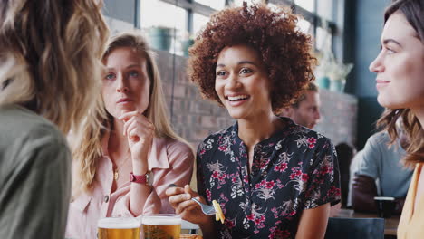 Four-Young-Female-Friends-Meeting-For-Drinks-And-Food-In-Restaurant