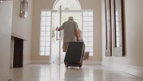 Älteres-Paar-Mit-Koffer,-Das-Die-Haustür-öffnet-Und-In-Den-Urlaub-Fährt