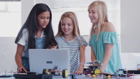 Drei-Studentinnen-Bauen-Und-Programmieren-Roboterfahrzeuge-Im-Computerprogrammierungskurs-Nach-Der-Schule