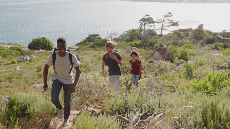 Group-Of-Young-Friends-Hiking-Up-Cliffs-On-Coastal-Path-Through-Countryside-Together