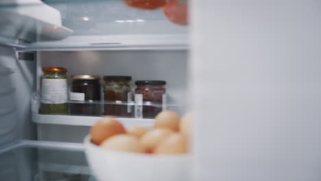 Blick-Aus-Dem-Inneren-Des-Kühlschranks,-Während-Ein-Paar-Die-Online-Lebensmittellieferung-Nach-Hause-Auspackt