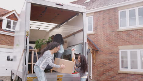 Family-Unloading-Furniture-From-Removal-Truck-Into-New-Home