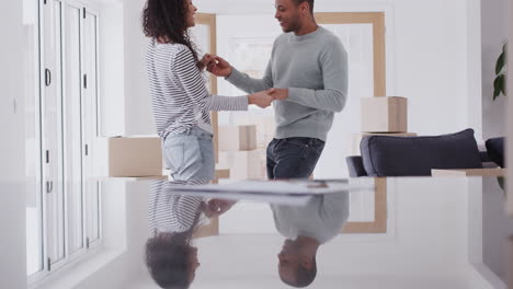 Loving-Couple-Dancing-Together-As-They-Celebrate-Moving-Into-New-Home