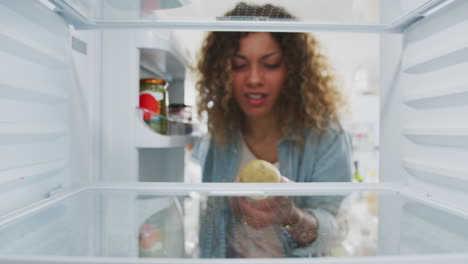 Disappointed-Woman-Looking-Inside-Refrigerator-Empty-Except-For-Potato-On-Shelf