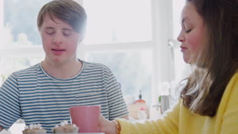 Junges-Down-Syndrom-Paar-Genießt-Tee-Und-Kuchen-In-Der-Heimischen-Küche