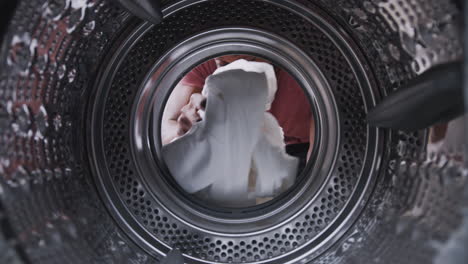 View-Looking-Out-From-Inside-Washing-Machine-As-Man-Puts-In-Laundry-Load