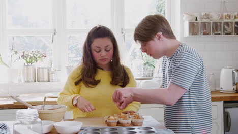 Young-Downs-Syndrome-Couple-Taking-Homemade-Cupcakes-Out-Of-Baking-Tray