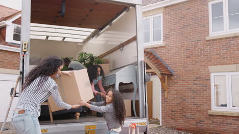 Family-Unloading-Furniture-From-Removal-Truck-Into-New-Home