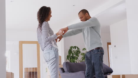 Loving-Couple-Dancing-Together-As-They-Celebrate-Moving-Into-New-Home
