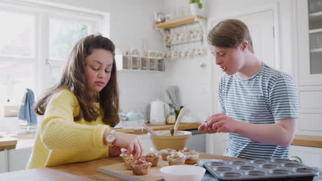 Junges-Down-Syndrom-Paar-Dekoriert-Hausgemachte-Cupcakes-Und-Tanzt-In-Der-Heimischen-Küche