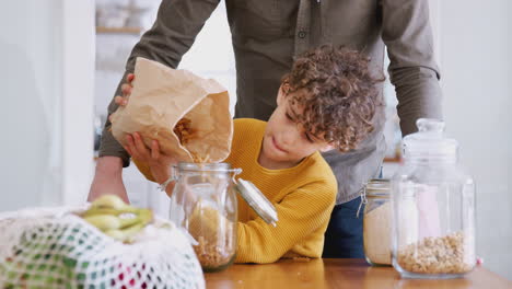 Father-Helping-Son-To-Refill-Food-Containers-At-Home-Using-Zero-Waste-Packaging