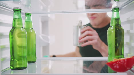 Blick-In-Den-Leeren-Kühlschrank,-Bis-Auf-Eine-Offene-Blechdose-Und-Eine-Flasche-Bier-Auf-Dem-Regal