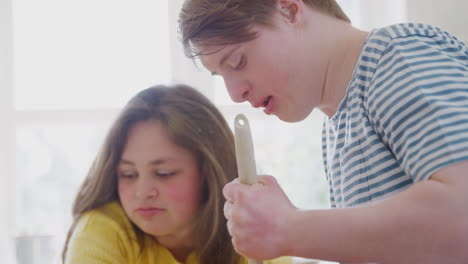 Junges-Paar-Mit-Down-Syndrom-Mischt-Zutaten-Für-Ein-Kuchenrezept,-Das-Sie-Zu-Hause-In-Der-Küche-Backen