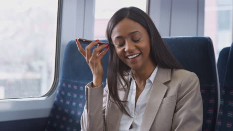 Businesswoman-Sitting-In-Train-Commuting-To-Work-Using-Mobile-Phone