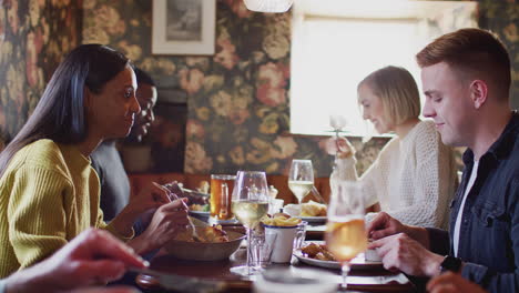 Group-Of-People-Eating-In-Restaurant-Of-Busy-Traditional-English-Pub