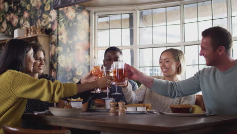 Group-Of-Friends-Making-A-Toast-As-They-Meet-For-Meal-In-Traditional-English-Pub