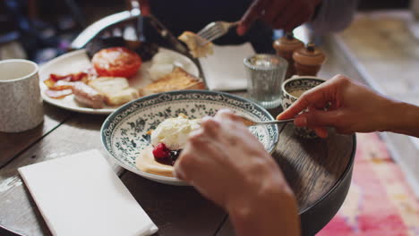 Nahaufnahme-Eines-Paares-Am-Tisch-In-Einem-Traditionellen-Englischen-Pub,-Das-Warmes-Frühstück-Und-Pfannkuchen-Isst