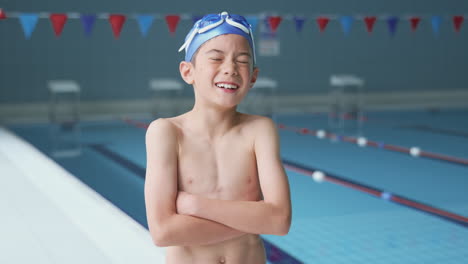 Portrait-Of-Boy-Standing-By-Edge-Of-Swimming-Pool-Ready-For-Lesson