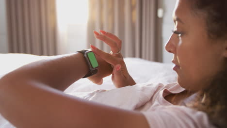 Frau-Sitzt-Im-Bett-Und-Schaut-Auf-Den-Bildschirm-Einer-Smartwatch
