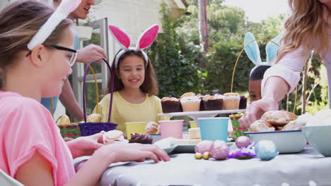 Parents-With-Children-Wearing-Bunny-Ears-Enjoying-Outdoor-Easter-Party-In-Garden-At-Home