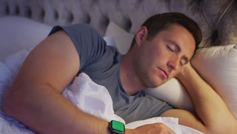 Mann-Liegt-Im-Bett-Und-Schaut-Vor-Dem-Schlafengehen-Auf-Die-Smartwatch