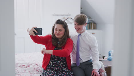 Liebevolles-Junges-Down-Syndrom-Paar-Sitzt-Auf-Dem-Bett-Und-Macht-Mit-Dem-Handy-Zu-Hause-Ein-Selfie