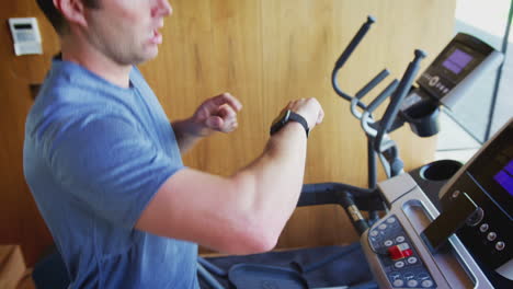 Man-Exercising-On-Treadmill-At-Home-Checking-Smart-Watch
