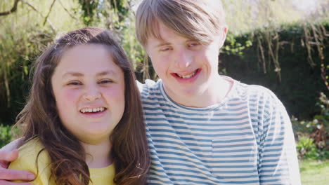 Outdoor-Portrait-Of-Loving-Young-Downs-Syndrome-Couple-In-Garden-At-Home-Together