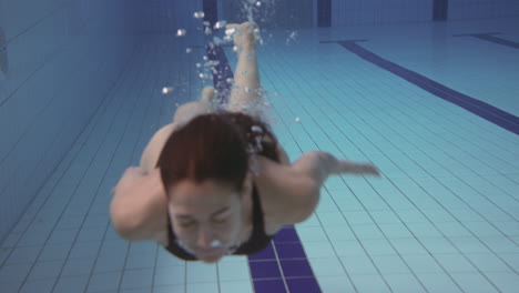 Unterwasseraufnahme-Einer-Frau,-Die-Im-Innenpool-Schwimmt