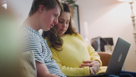 Junges-Down-Syndrom-Paar-Sitzt-Zu-Hause-Auf-Dem-Sofa-Und-Benutzt-Laptop
