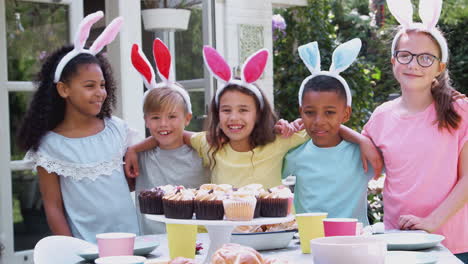 Portrait-Of-Children-Wearing-Bunny-Ears-Enjoying-Outdoor-Easter-Party-In-Garden-At-Home