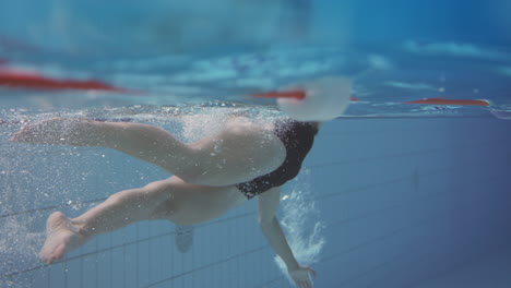 Underwater-Shot-Of-Woman-Swimming-In-Indoor-Pool