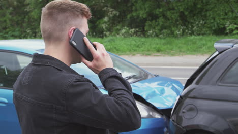 Young-Male-Motorist-Involved-In-Car-Accident-Calling-Insurance-Company-Or-Recovery-Service