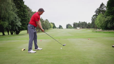 Mature-Male-Golfer-Hitting-Tee-Shot-Along-Fairway-With-Driver