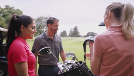 Group-Of-Male-And-Female-Golfers-Standing-By-Golf-Buggy-On-Course-And-Choosing-Clubs