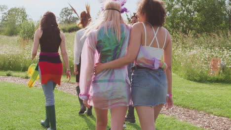 Rear-View-Of-Excited-Young-Female-Friends-Walking-Through-Music-Festival-Site