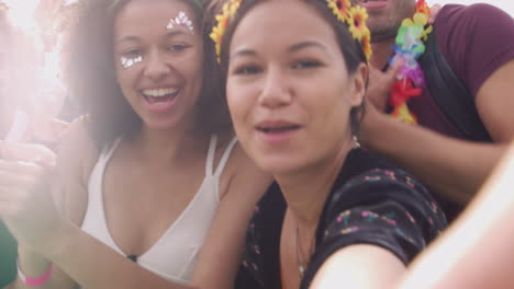 Group-Of-Young-Friends-Dancing-Behind-Barrier-Taking-Selfie-At-Outdoor-Music-Festival