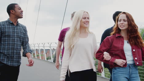 Group-Of-Student-Friends-Walking-Across-Bridge-In-City-Together
