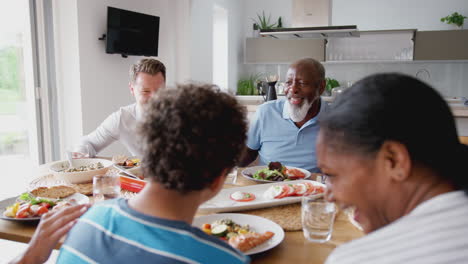 Mehrgenerationenfamilie-Mit-Gemischter-Rasse,-Die-Zu-Hause-Gemeinsam-Am-Tisch-Isst