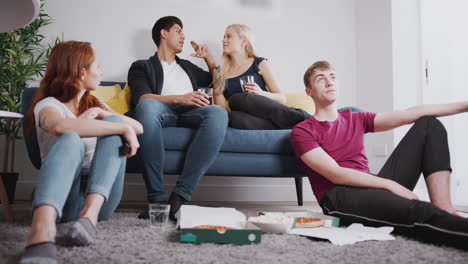 Gruppe-Von-College-Studenten-Im-Gemeinsamen-Haus,-Die-Fernsehen-Und-Pizza-Essen