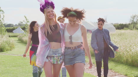 Group-Of-Excited-Young-Female-Friends-Walking-Through-Music-Festival-Site
