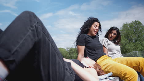 Three-Female-Friends-Meeting-And-Relaxing-In-Urban-Skate-Park