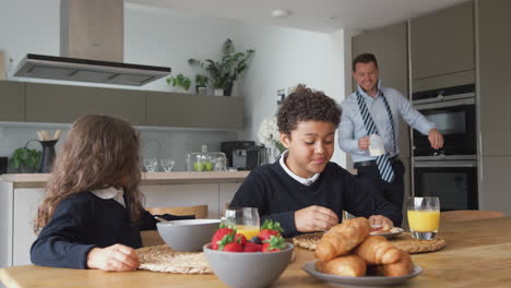 Businessman-Father-In-Kitchen-Helping-Children-With-Breakfast-Before-Going-To-School