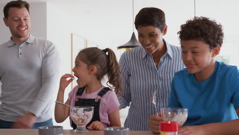 Parents-Catch-Children-In-Kitchen-At-Home-Eating-Ice-Cream