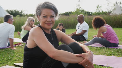 Porträt-Einer-Reifen-Frau-Auf-Einem-Yoga-Retreat-Im-Freien-Mit-Freunden-Und-Einem-Campingplatz-Im-Hintergrund