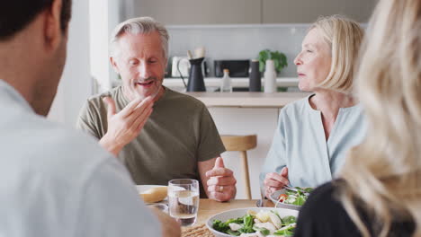Familie-Mit-älteren-Eltern-Und-Erwachsenen-Nachkommen,-Die-Zu-Hause-Gemeinsam-Am-Tisch-Essen