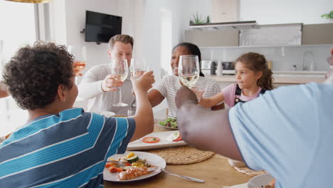 Mehrgenerationenfamilie-Mit-Gemischter-Rasse-Stößt-Vor-Dem-Gemeinsamen-Essen-Am-Tisch-Zu-Hause-An