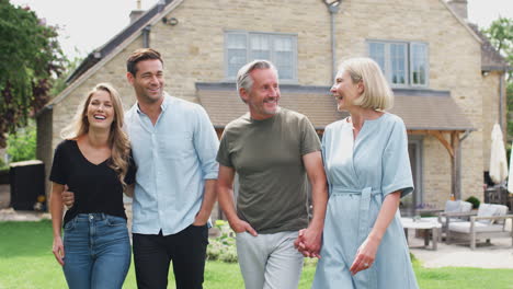 Family-With-Senior-Parents-And-Adult-Offspring-Walking-And-Talking-In-Garden-Together